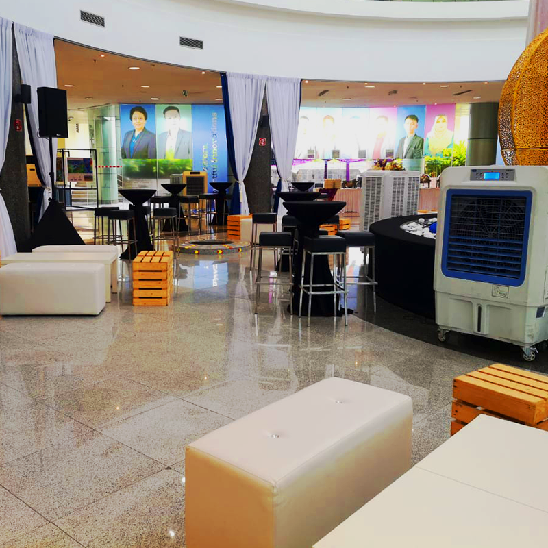 A display of TK Rentals’ air cond rental units in a compact indoor setting surrounded by sofas and other furniture.