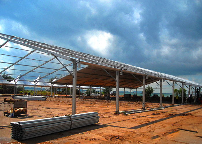 An outdoor setup of tent rental frame at sandy location.