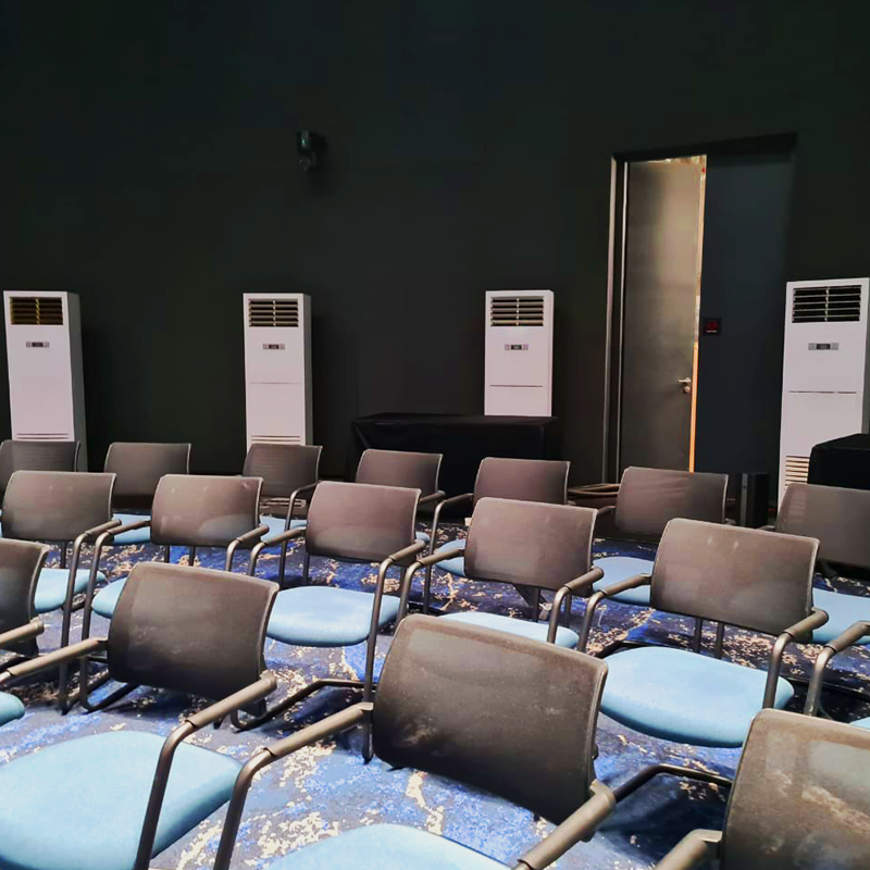 A display of TK Rentals’ 5HP Floor Standing air cond rental units inside a room setup with chair arranged in a seating position.
