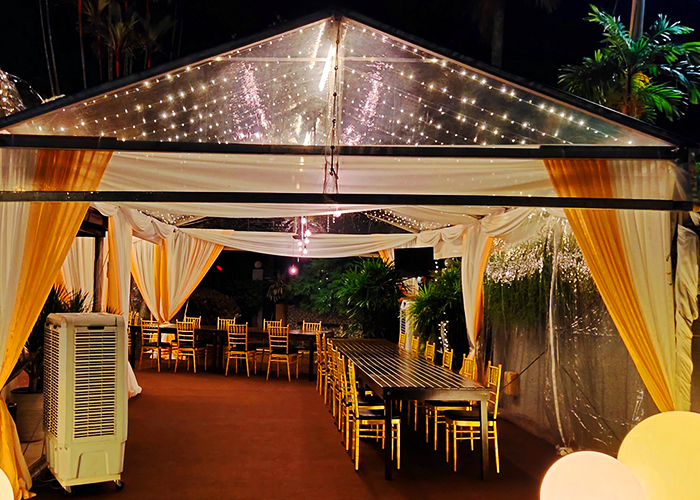 TK Rentals’ Transparent Roof Marquee Tent rental on display for an event, housing multiple furniture and equipment within.